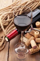 Glass of red wine, bottle and corks