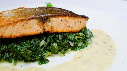 Salmon steak on spinach, selective focus