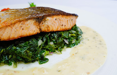 Salmon steak on spinach, selective focus