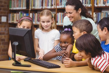 Pupils and teacher in the library using computer