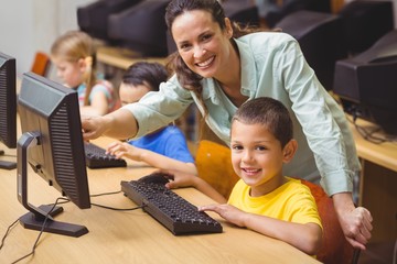 Cute pupils in computer class with teacher