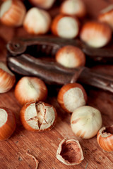 Cracking hazelnuts on wooden table closeup. Organic food, Healthy eating. 