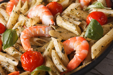 Pasta with shrimp and pesto on a plate macro. horizontal
