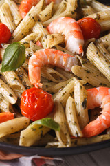 Penne pasta with shrimp, tomato and pesto macro. Vertical
