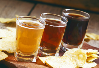 Three kinds of beer and potato chips, selective focus