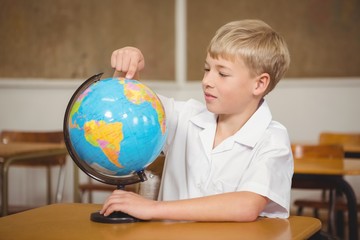 Pupil pointing to a place on a globe