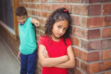 Upset child being teased by another child