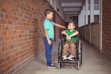Smiling student in a wheelchair and friend beside him