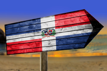 Dominican Republic Flag on wooden table sign on beach background