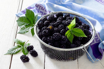 Berries ripe blackberries on a white wooden table