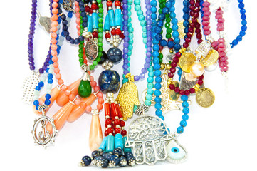 Close-up on very colourful handmade necklaces isolated by white background