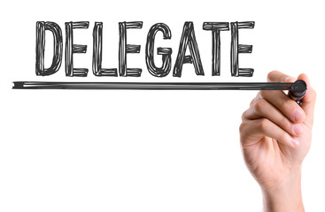Hand with marker writing the word Delegate