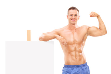 Muscular man standing by a banner and showing bicep