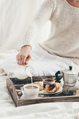 Woman having breakfast in bed. Window light