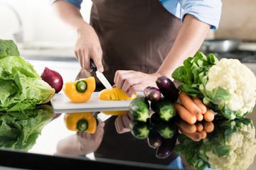 Man cooking and preparing salad in kitchen