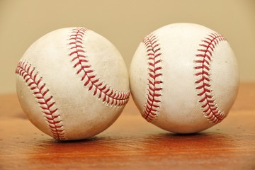 Objects: Two baseballs on a wood table close up