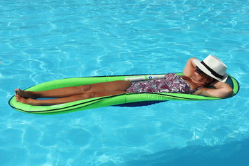 An english Lady relaxing in a swimming pool while on holiday