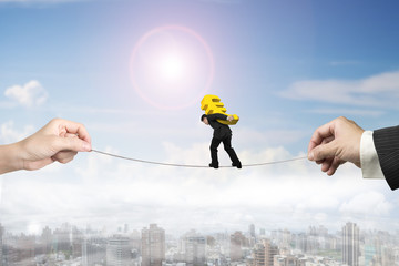 Businessman carrying euro sign balancing tightrope with hands ho