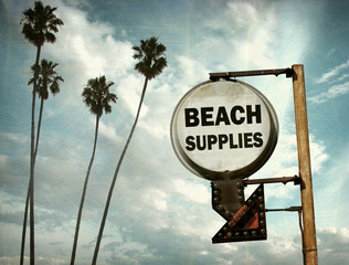 aged and worn vintage photo of beach supplies sign