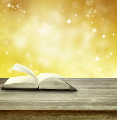 Book on table and blurred golden background