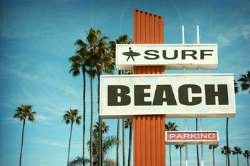 aged and worn vintage photo of surf beach sign with palm trees