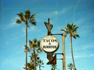 aged and worn vintage photo of tacos and burritos sign with palm trees
