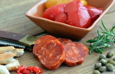 Chorizo - Spanische Wurst auf Holz mit Paprika, Messer und Rosmarin