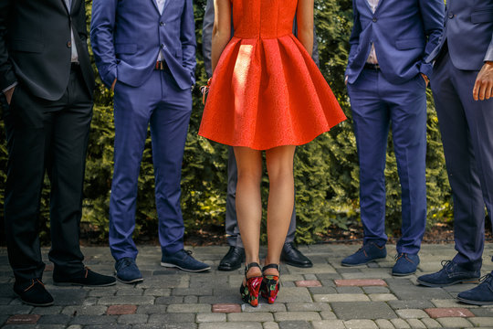 Five Mans In Suits And One Female In Orange Dress.