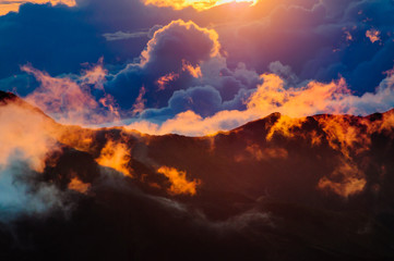 Sunrise over clouds and distant mountains from Haleakala Crater.