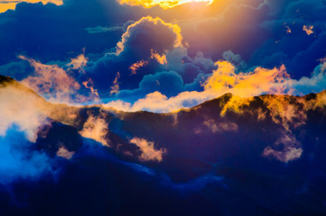 Sunrise over clouds and distant mountains from Haleakala Crater.