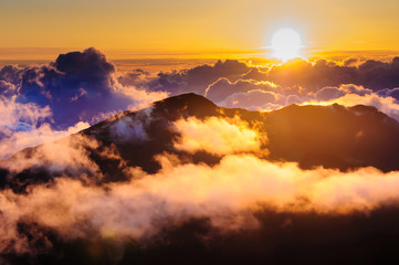 Sunrise over clouds and distant mountains from Haleakala Crater.