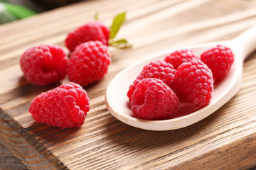 Red raspberries on cutting board on grey wooden background