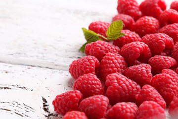 Red raspberries on white wooden background