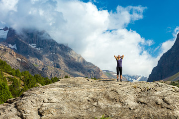 Young woman doing morning fitness outdoor in mountain landscape