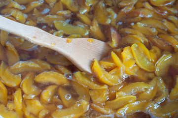 shot of cooking and preparing homemade peach jam in a pot.