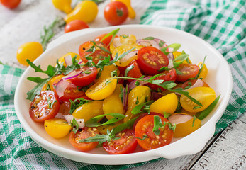 Salad of fresh cherry tomatoes with onion and arugula