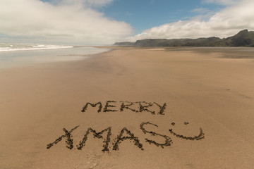 merry xmas handwritten in sand