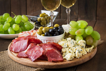 Antipasto catering platter with bacon, jerky, salami, cheese and grapes 
