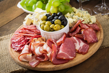 Antipasto catering platter with bacon, jerky, salami, cheese and grapes 