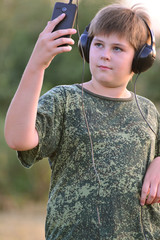 Boy listening to music on headphones with smartphone