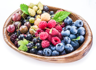 Berries in the wooden bowl on a white.