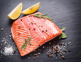 Fresh salmon on the black cutting board.