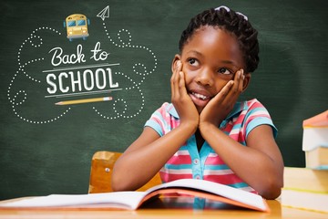 Composite image of pupil sitting at her desk 