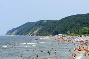 Tourists enjoy the sunny weather and relaxing on the Baltic sea beach in Miedzyzdroje, Poland.