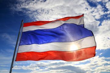Thailand flag waving in the wind with beautiful blue sky and sun