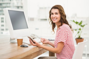 Smiling casual businesswoman using smartphone