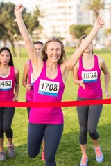 Obraz premium Cheering blonde winning breast cancer marathon