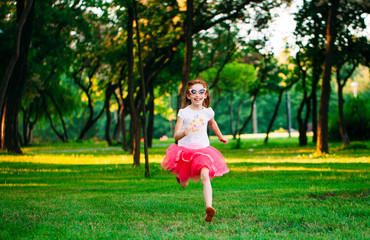 Naklejka na ściany i meble little girl running in the park