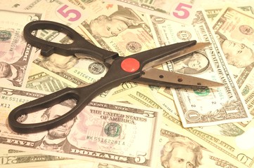 Budget cut concept with scissors and US dollars