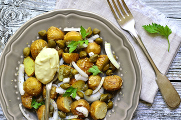 Young potato salad with capers and marinated onion.